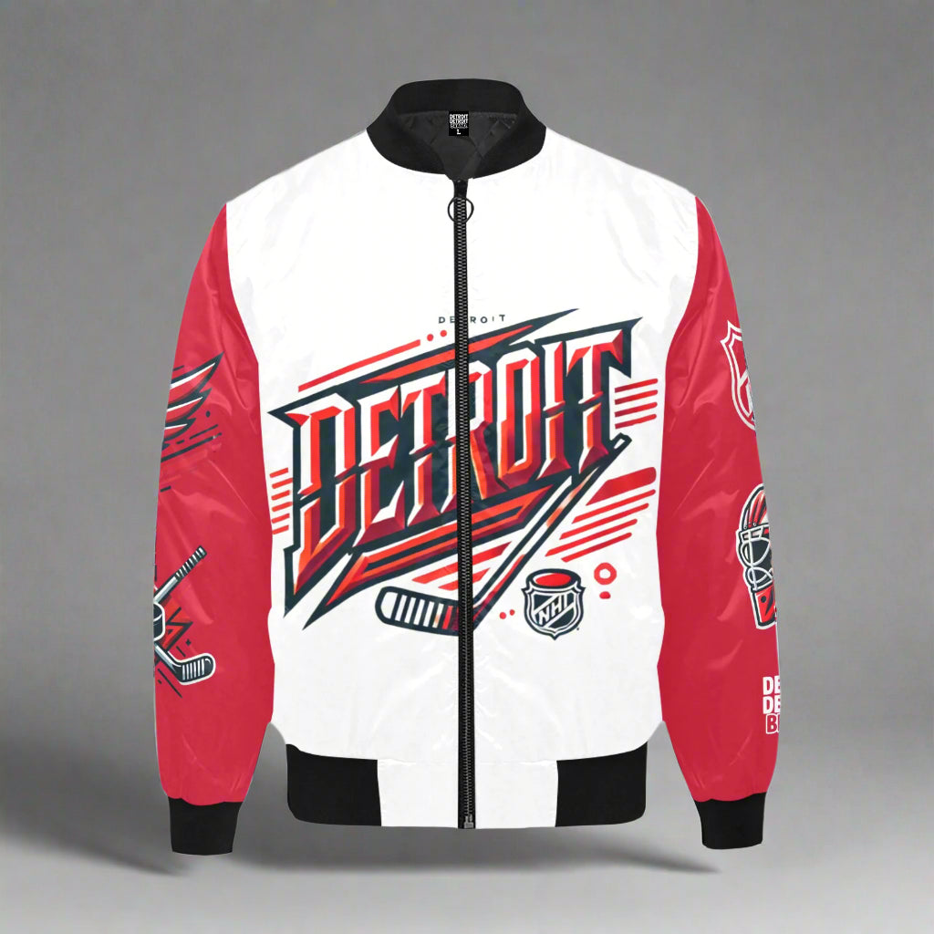 Detroit-themed bomber jacket displayed flat against a gray background. The jacket features a bold design with a white front and red sleeves. The word 'DETROIT' is printed in large red, black, and white 3D-style lettering across the chest, with hockey sticks, puck, and NHL logo graphics integrated into the design. The red sleeves display additional hockey-related graphics, including a goalie mask and stick. The jacket has black ribbed collar, cuffs, waistband, and a black zipper