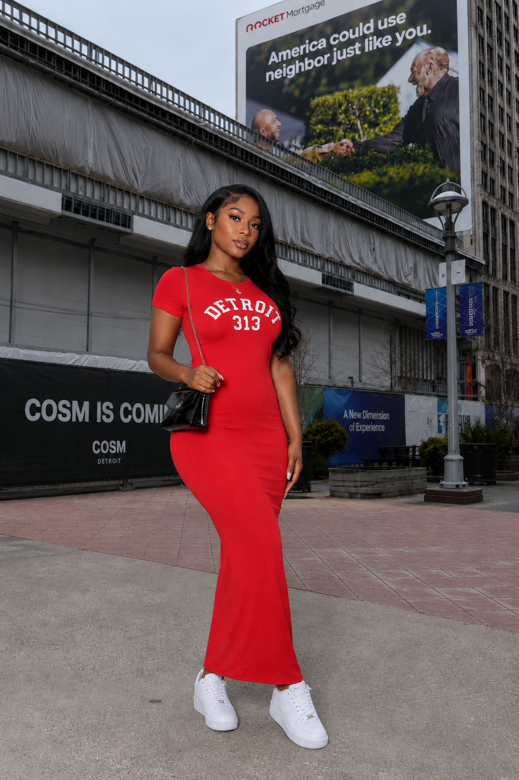 Woman wearing red Detroit 313 fitted maxi dress with white sneakers in downtown Detroit