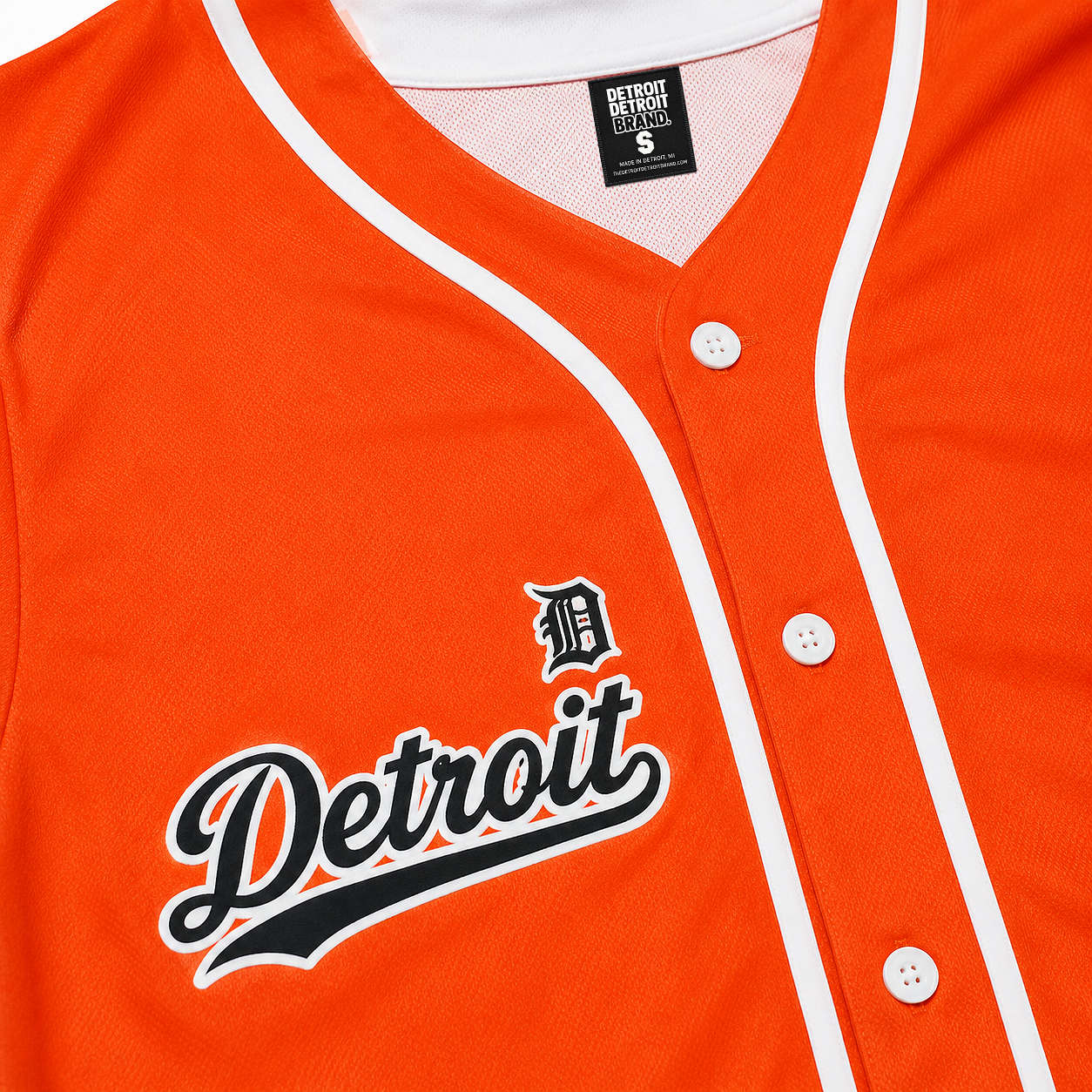 Close-up of the Detroit Script Orange Baseball Jersey showing the embroidered-style Detroit script, Old English D logo, buttons, and premium mesh fabric.