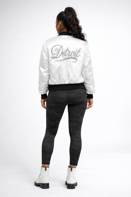 Person wearing a white jacket with 'Detroit' text on the back, standing against a white background.