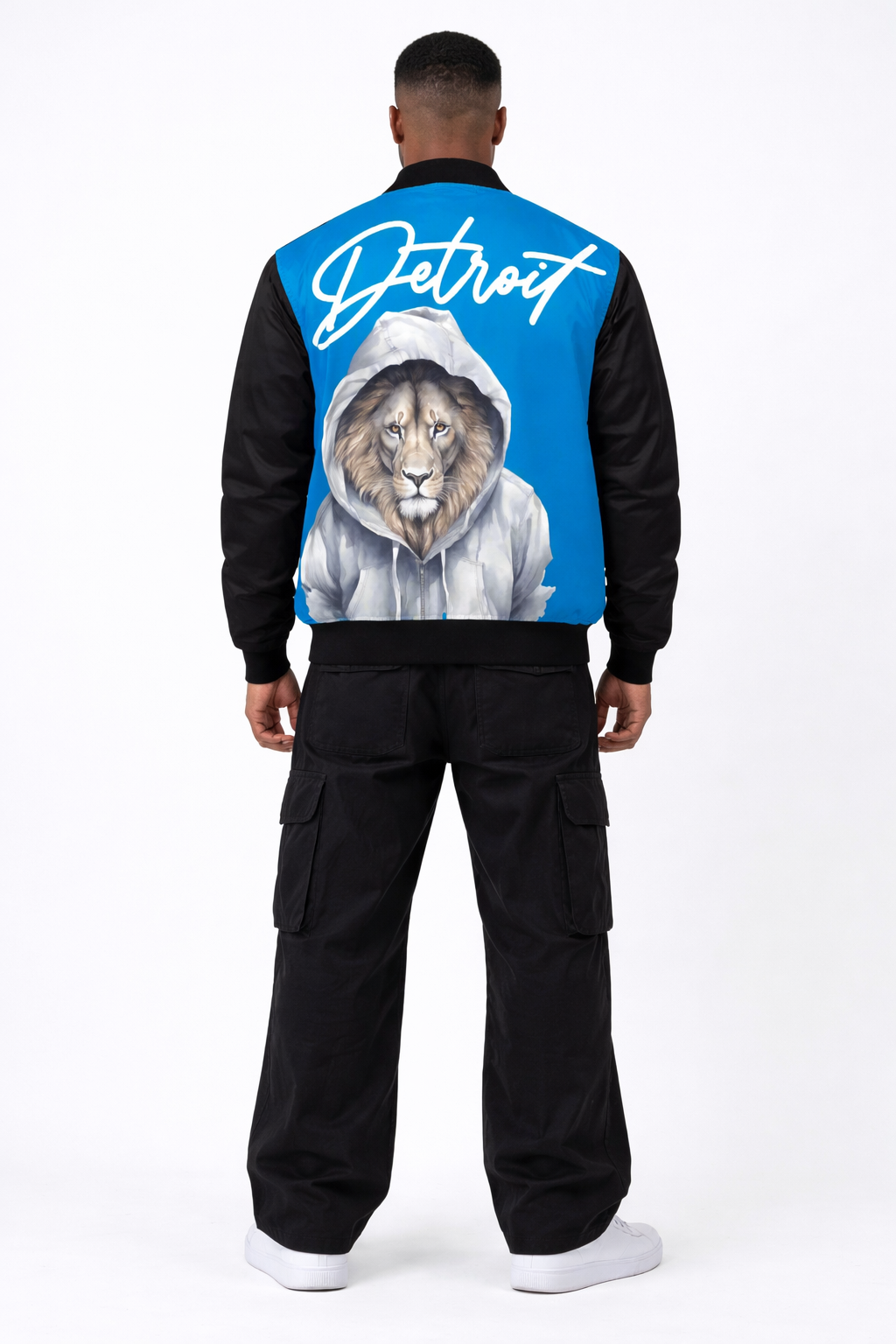 Person wearing a black jacket with a blue back featuring a lion and 'Detroit' text on a white background