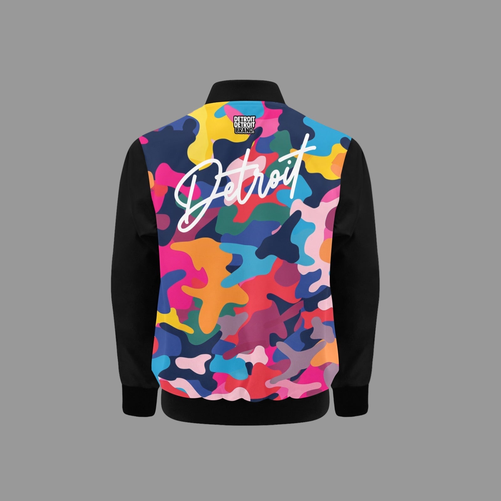 Kids jacket featuring a bold multi-color camo design with black sleeves, a white “Detroit” script across the chest, and a gold zipper with black ribbed collar, cuffs, and hem.