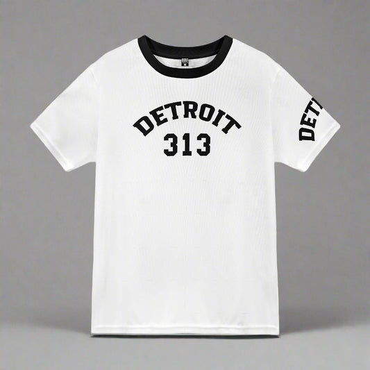 White short-sleeve t-shirt displayed flat against a gray background. The shirt features black text with the word 'DETROIT' arched above the number '313' on the front. The left sleeve also displays the word 'DETROIT' in black capital letters. The shirt has a black crew neckline, adding a contrasting accent