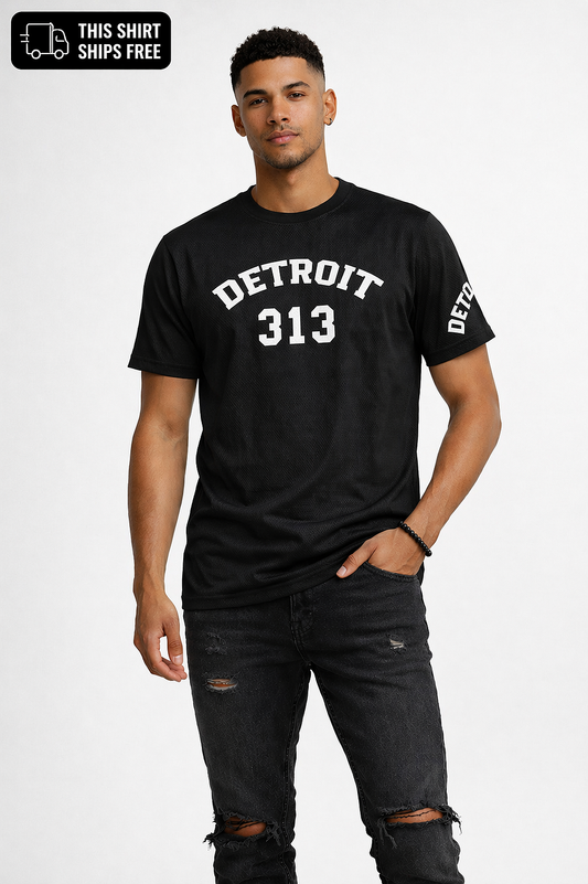 Male model wearing black Detroit 313 t-shirt with white lettering, distressed black jeans and black sneakers on white background