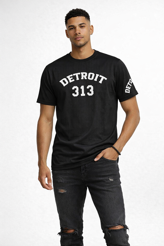 Male model wearing black Detroit 313 t-shirt with white lettering, distressed black jeans and black sneakers on white background