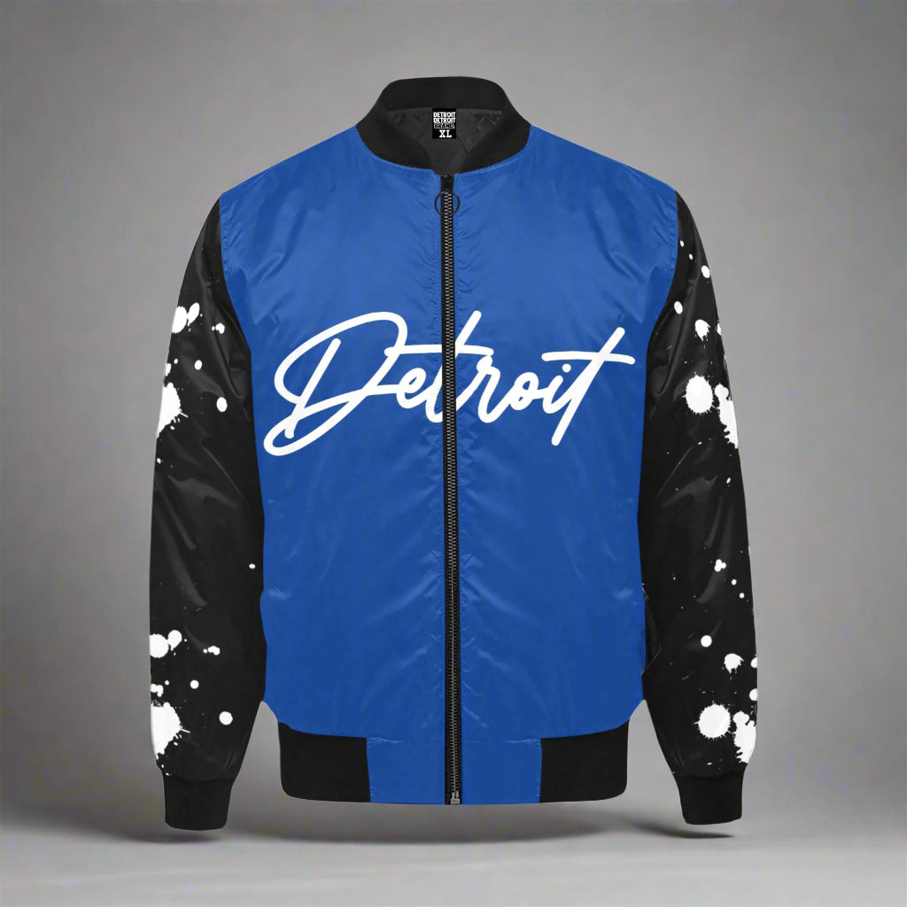 Blue Detroit bomber jacket with black sleeves featuring white paint-splatter design and bold white Detroit script on the front