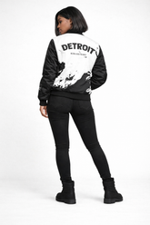 Back view of Detroit Born and Raised black and white splatter bomber jacket showing large Detroit Born and Raised lettering in white studio setting
