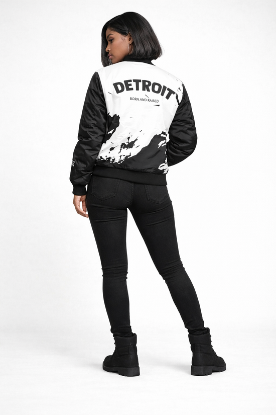 Back view of Detroit Born and Raised black and white splatter bomber jacket showing large Detroit Born and Raised lettering in white studio setting