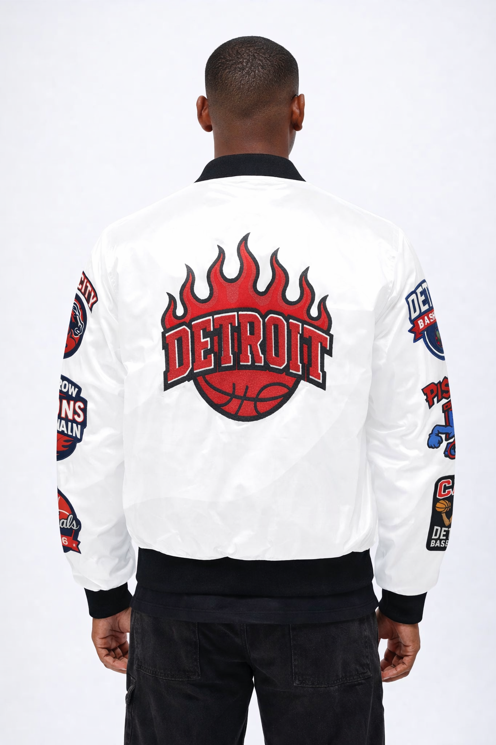 Person wearing a white 'Detroit Pistons' jacket with flame 'Detroit' design on the back, on a white background