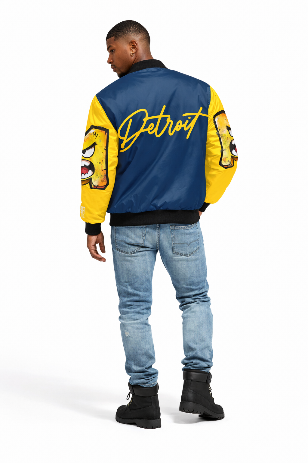 Person wearing a blue and yellow 'U of M' jacket with 'Detroit' text on the back, standing against a white background.