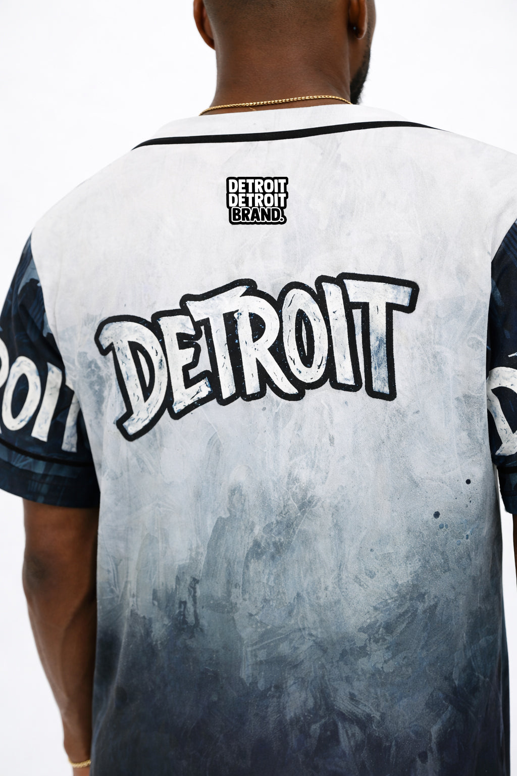 Close-up back view of Detroit grey and black baseball jersey featuring large Detroit graphic and Detroit Detroit Brand logo