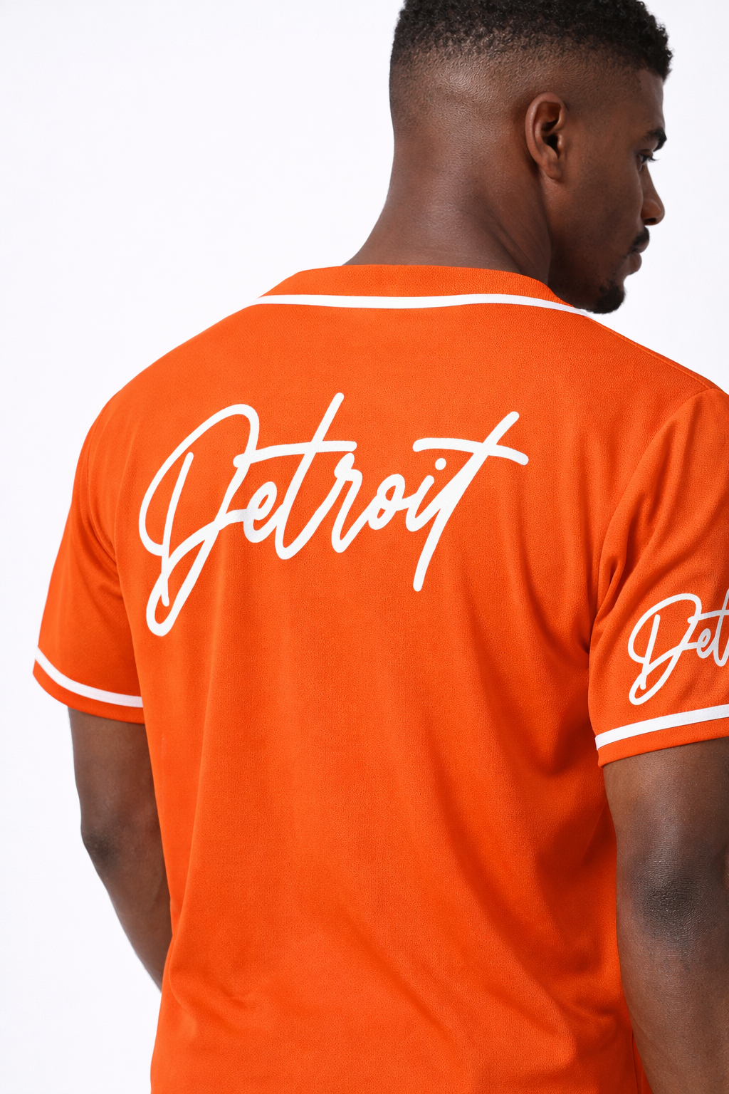 Back view of men’s orange Detroit baseball jersey showing large Detroit script logo and white trim details