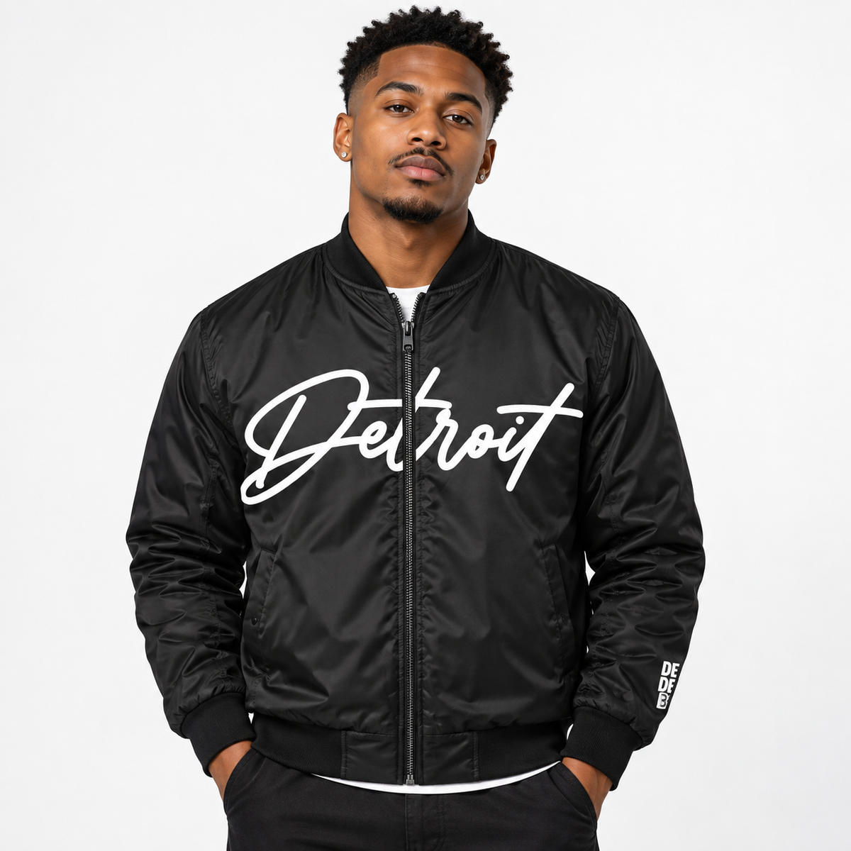 Male model wearing black Detroit Script Bomber Jacket with white Detroit lettering on front