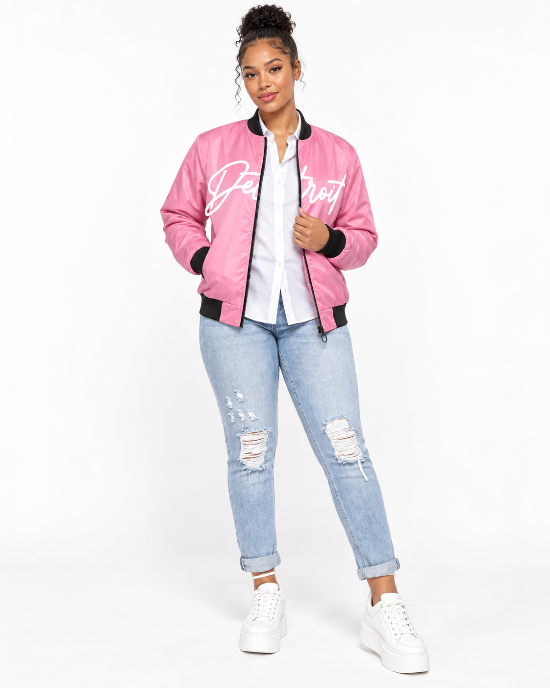 Female model wearing Detroit Script pink bomber jacket with white shirt and jeans