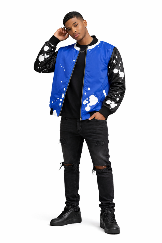 Brown skin male model wearing Detroit Splatter Bomber Jacket in royal blue and black with distressed black jeans and black Air Force 1 sneakers on white background