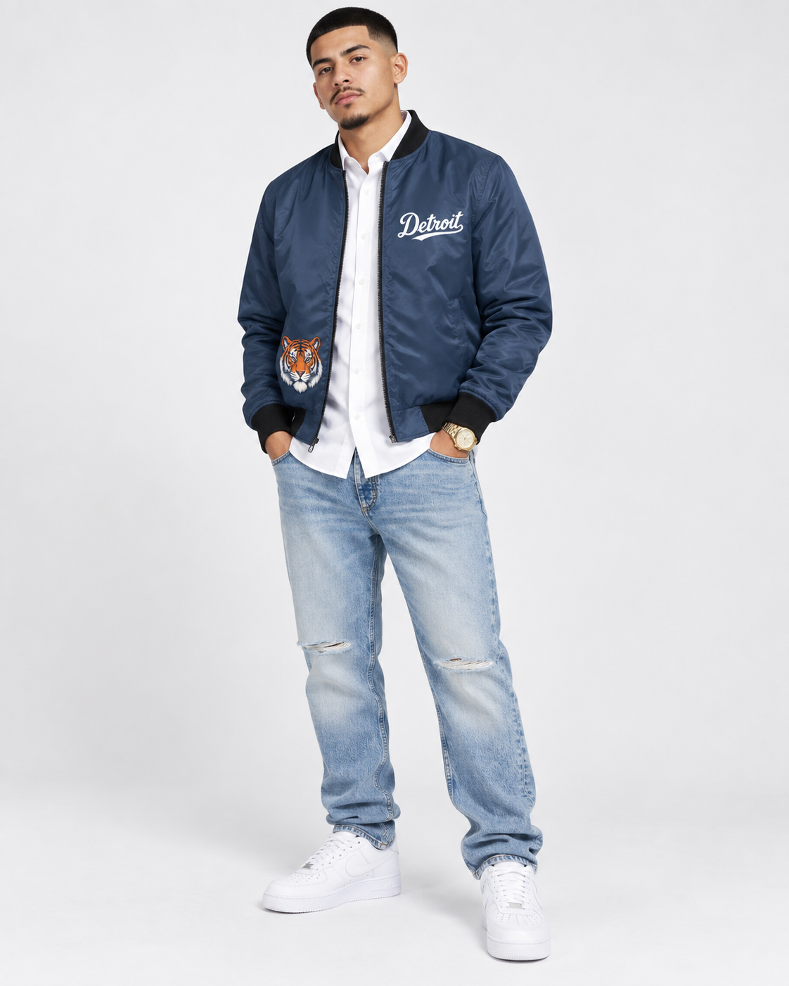 Male model wearing navy Detroit Tiger bomber jacket with Detroit script and tiger graphic