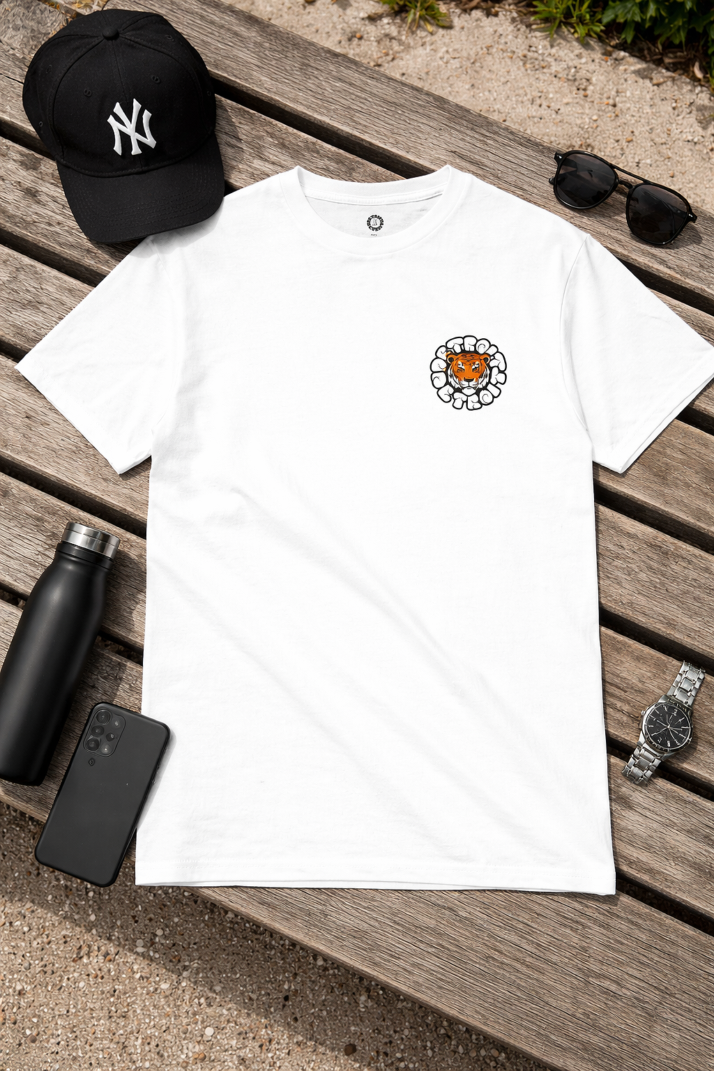 White Detroit tiger graphic t-shirt flat lay on wooden surface with lifestyle accessories, outdoor setting