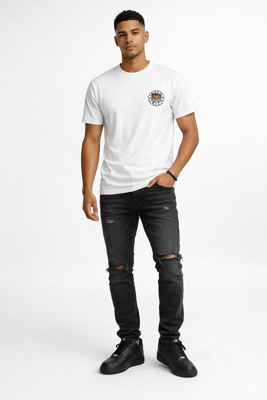Light brown skin male model wearing Detroit tiger graphic t-shirt, distressed black jeans and black Nike Air Force 1 sneakers, full body front view on white background