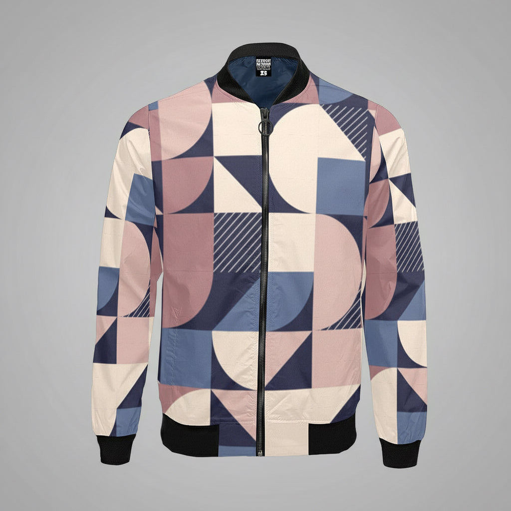 Geometric-patterned bomber jacket featuring abstract shapes in soft pink, navy blue, cream, and light blue tones. The jacket has a front zipper, black collar, cuffs, and waistband, creating a modern, stylish look.
