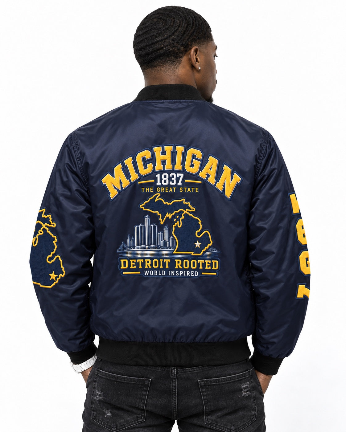 Black male model wearing Michigan Detroit Rooted Bomber Jacket from the back showing large printed Detroit Rooted graphic