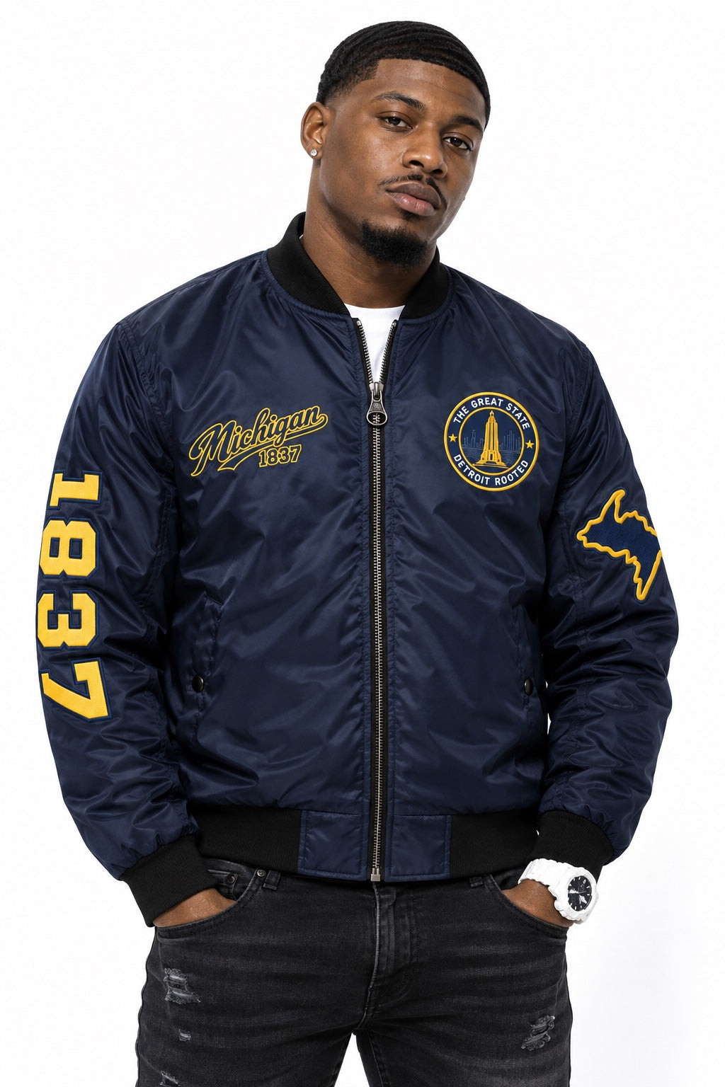 Black male model wearing navy Michigan Detroit Rooted Bomber Jacket with maize printed graphics