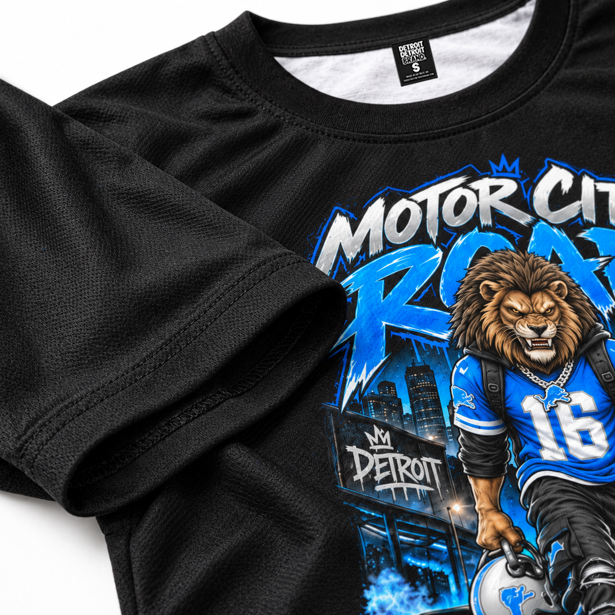 Close-up of Motor City Roar Detroit football artwork and polyester material on black graphic T-shirt
