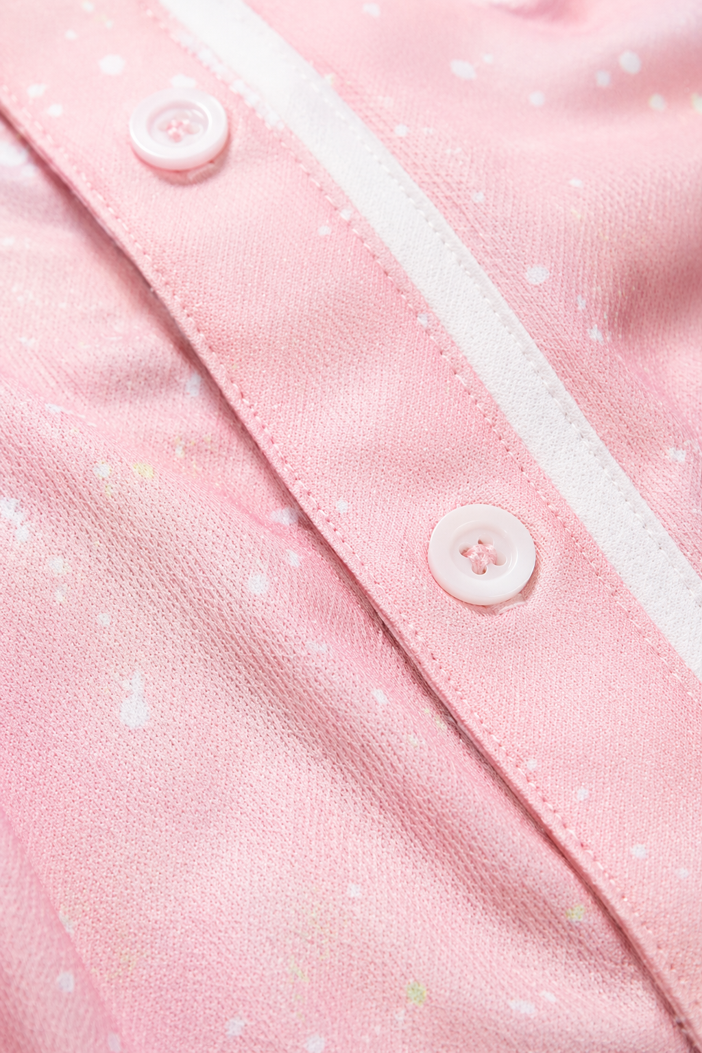 Close-up detail of pink Detroit baseball jersey showing stitching, button placket, and white piping with textured fabric