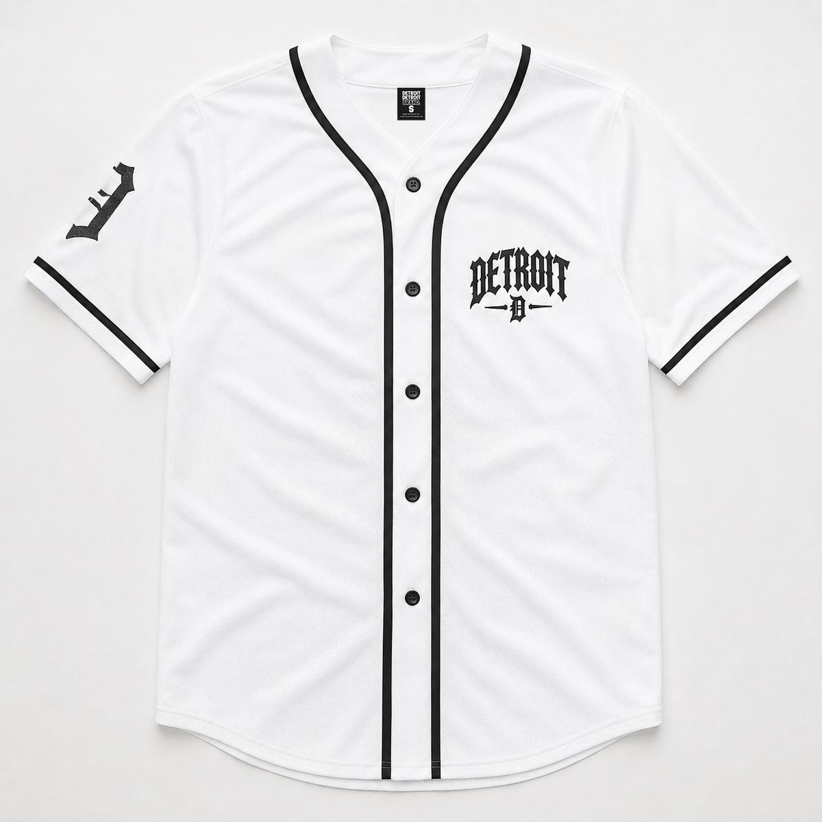 A white short-sleeve baseball-style jersey with black trim, black buttons, a black Detroit logo on the left chest, and a black stylized logo on the right sleeve, shown flat against a light gray background.